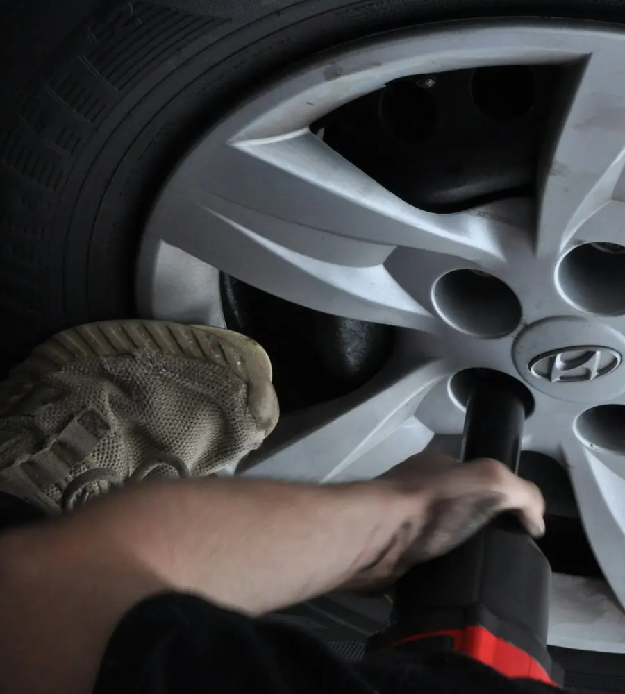 Mobile tyre technician balancing a wheel at the rear of a fully equipped service van